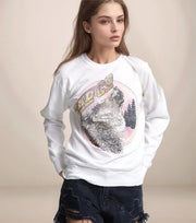 Person wearing a white sweatshirt with a wolf graphic and 'REDCO' text on a beige background