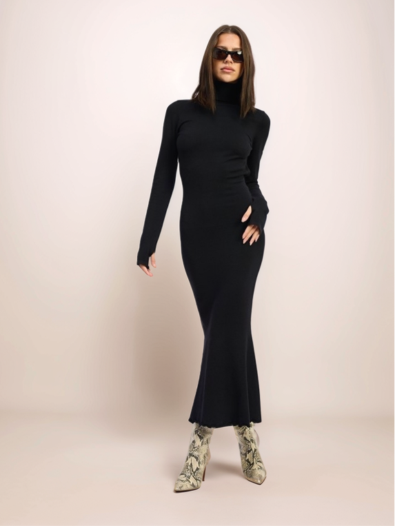Woman wearing a black long-sleeve dress and sunglasses on a beige background