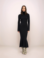 Woman wearing a black dress against a white background