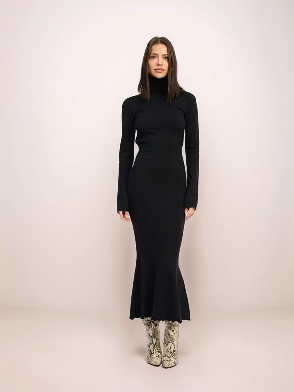 Woman wearing a black dress against a white background
