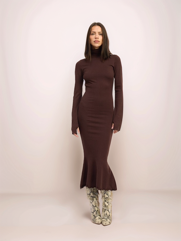 Woman wearing a brown long-sleeve dress with a fitted silhouette on a plain background
