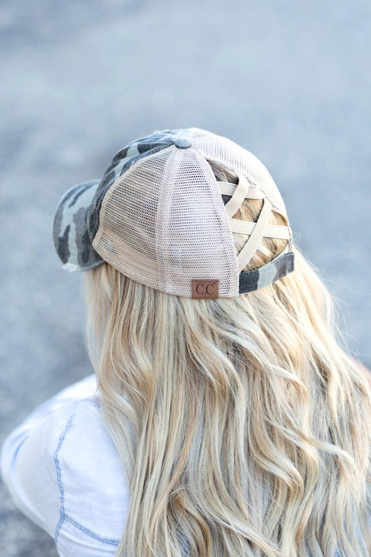 Person wearing a camouflage baseball cap with a mesh back against a blurred background