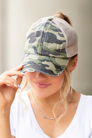 Woman wearing a camouflage cap with a plain background