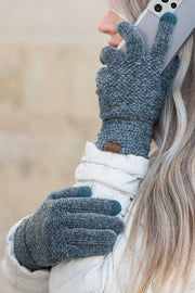 Person wearing blue gloves using a smartphone outdoors