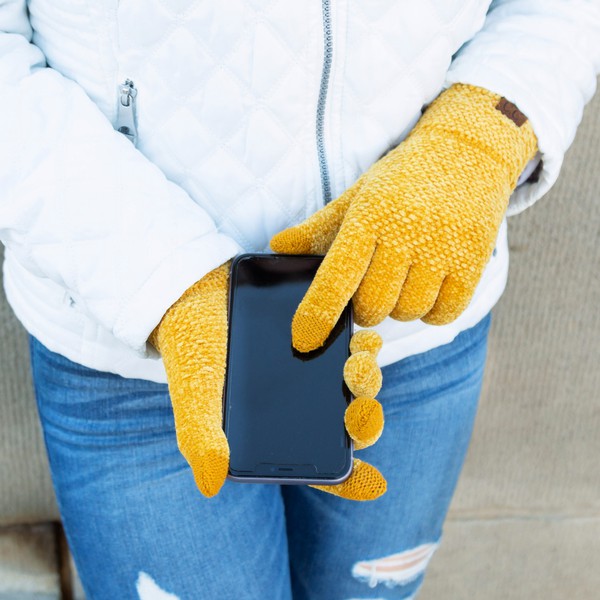 Person wearing yellow gloves holding a phone with a blurred background