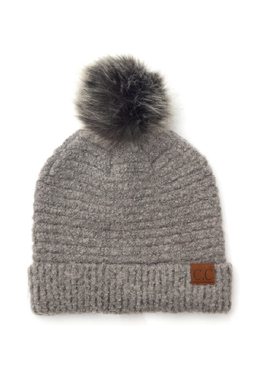Gray knit beanie with a pom-pom on a white background