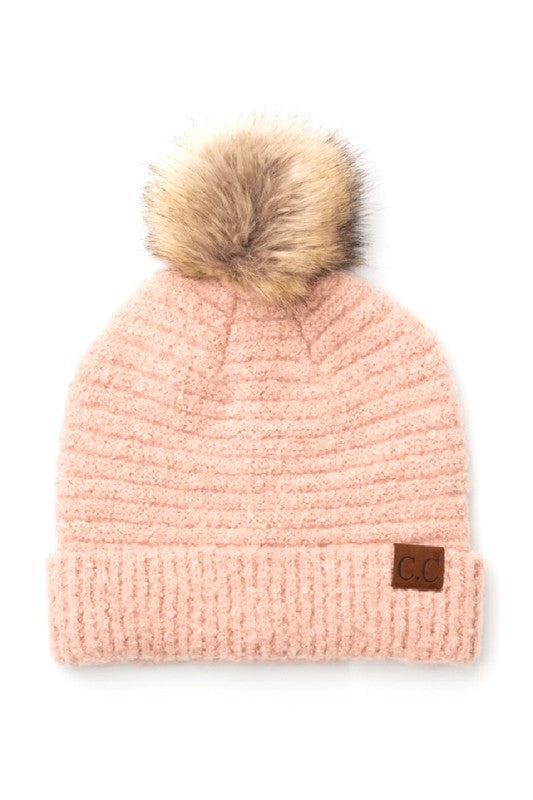 Pink knit beanie with a fur pom-pom on a white background