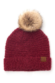 Red knit beanie with a fur pom-pom on a white background