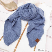 Denim blue scarf with a brown label on a white surface