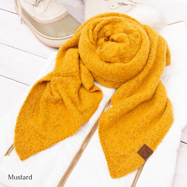 Mustard yellow scarf with a brown tag on a white background