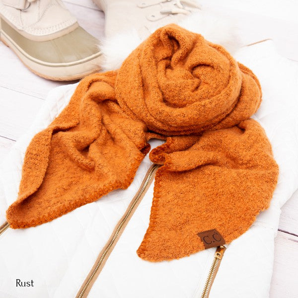 Orange scarf with a brand logo on a white surface