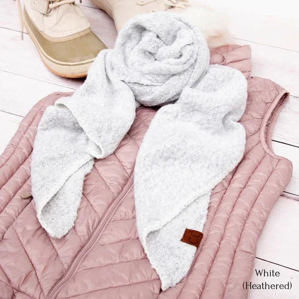 Pink quilted jacket with white heathered scarf on a light wooden floor