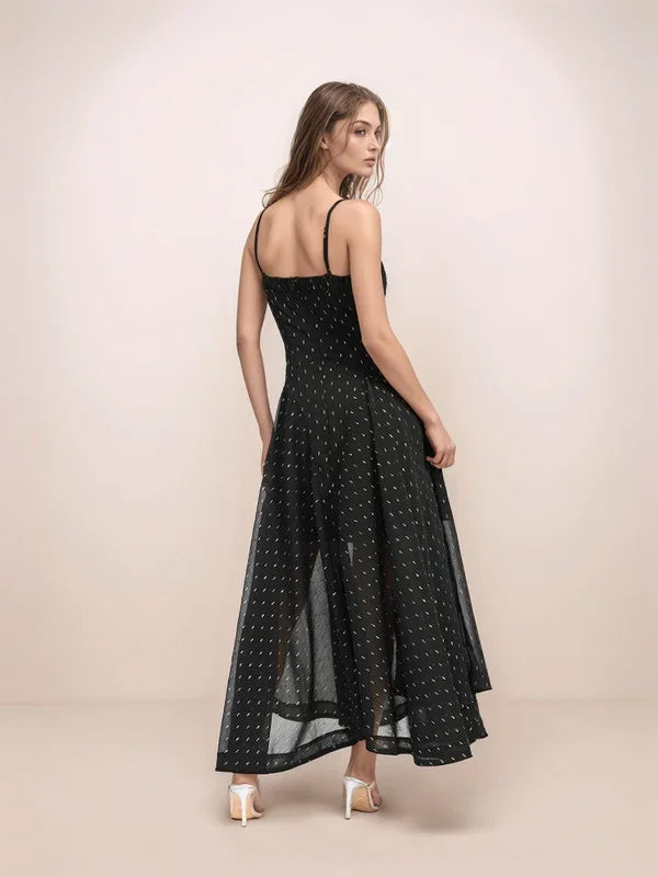 Woman wearing a black polka dot dress against a beige background