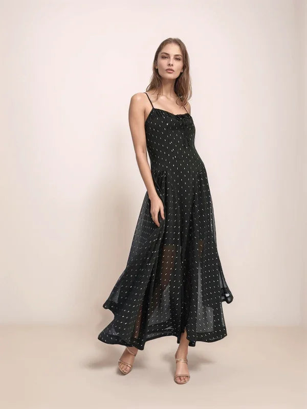 Woman wearing a black dress with silver dots on a beige background