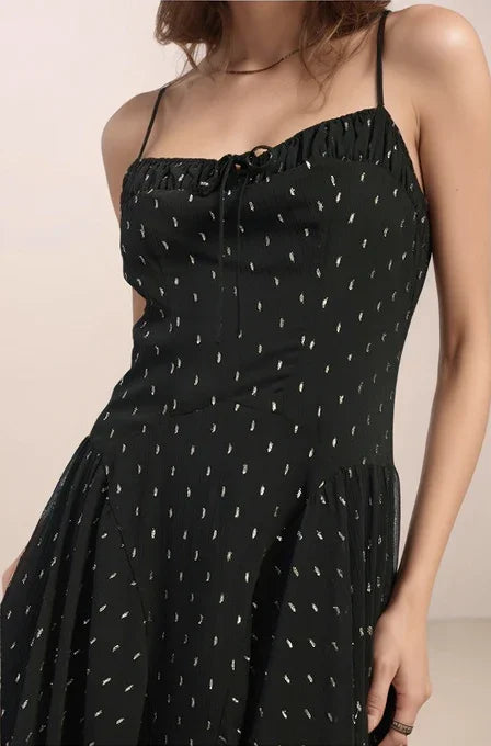 Black dress with silver pattern on a beige background