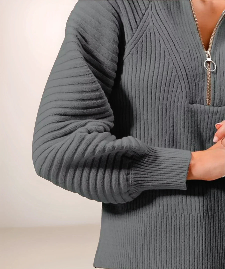 Gray ribbed sweater with a quarter zip on a neutral background