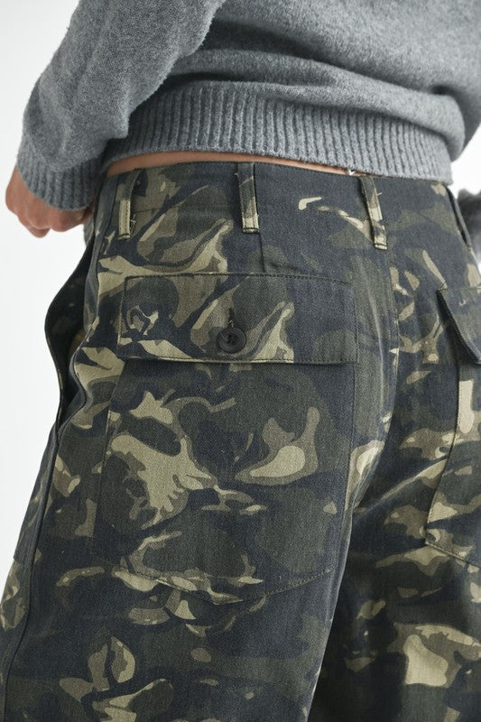 Camouflage pants worn by a person with a gray sweater.