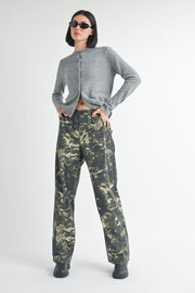 Person wearing a gray cardigan and camouflage pants on a white background