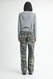 Person wearing a gray sweater and camouflage pants on a white background
