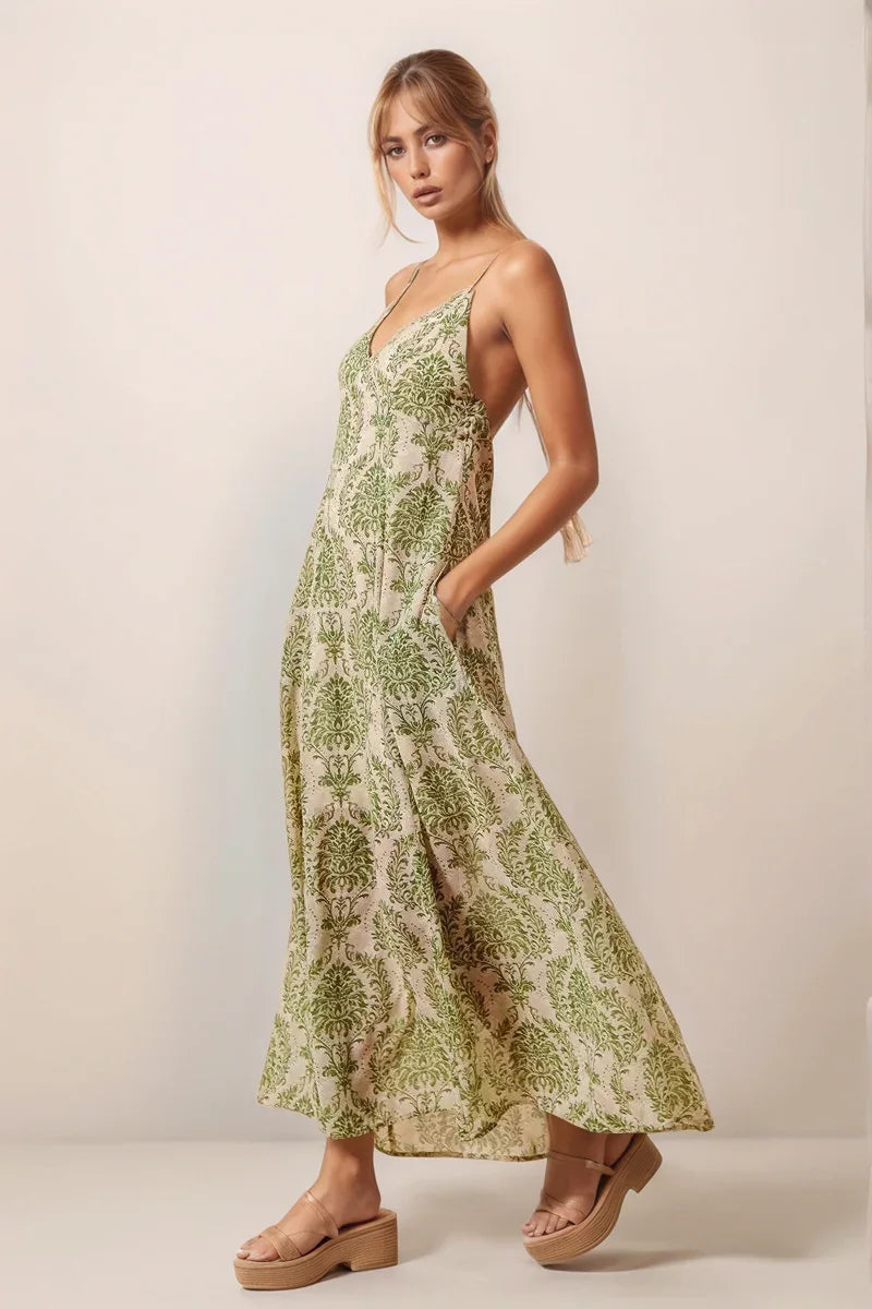 Side view of the green floral damask maxi dress showcasing the model with hands in the hidden side pockets.