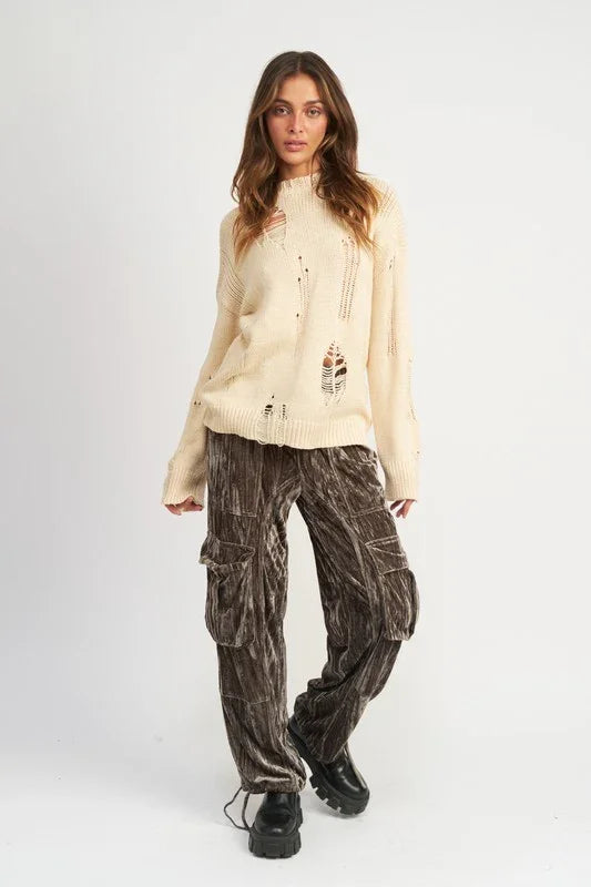 Woman wearing a beige jacket and brown cargo pants on a white background