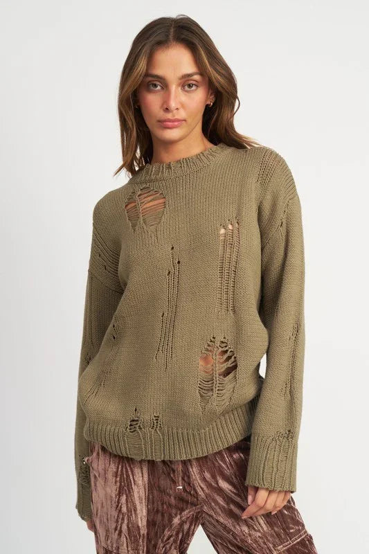 Woman wearing a distressed olive green sweater on a white background