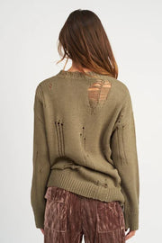 Person wearing a green distressed sweater on a white background