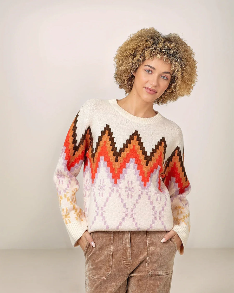 Woman wearing a patterned sweater with a plain background