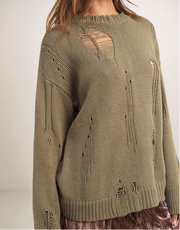 Green knitted sweater with cut-out design on a plain background