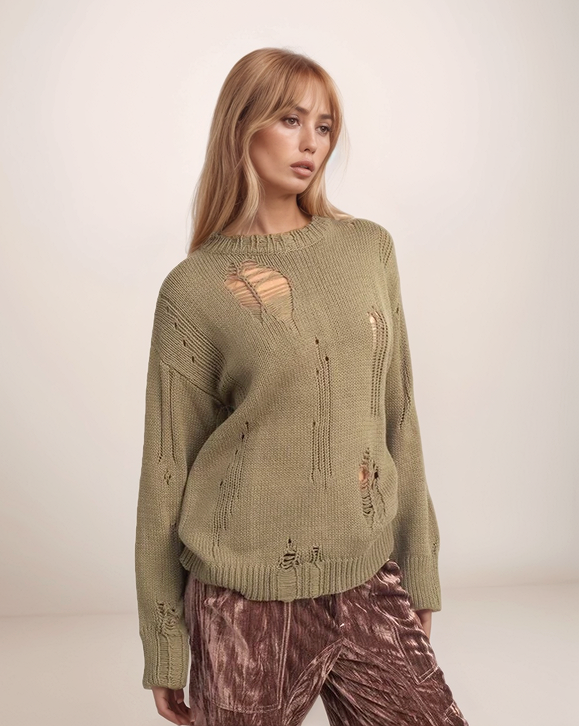 Woman wearing a green distressed sweater with a plain background