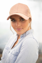 Woman wearing a peach baseball cap with a blurred background