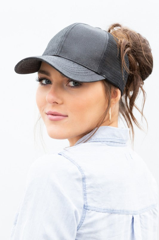 Woman wearing a gray baseball cap with a ponytail, on a white background