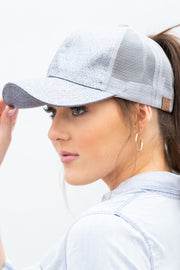 Woman wearing a gray mesh cap with a blurred background