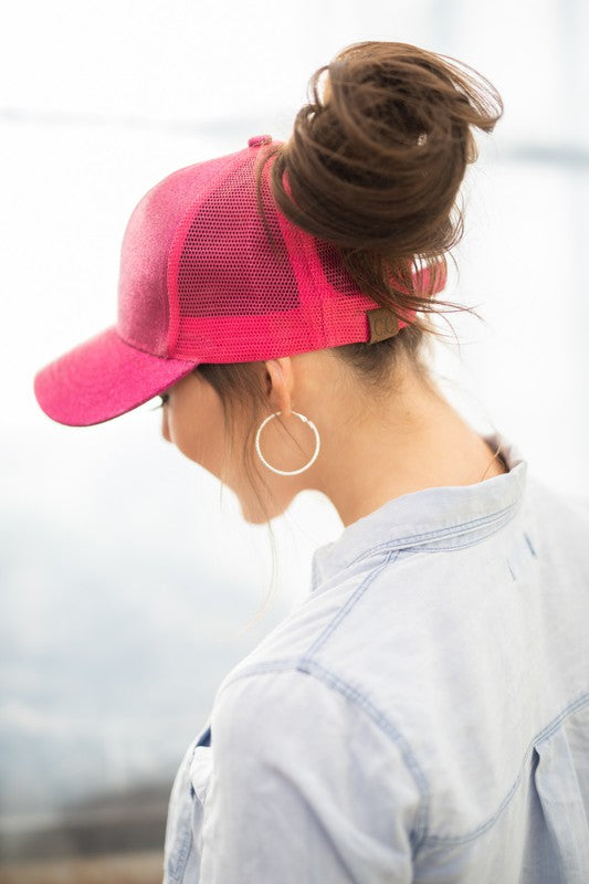 Person wearing a pink cap and hoop earring with a blurred background