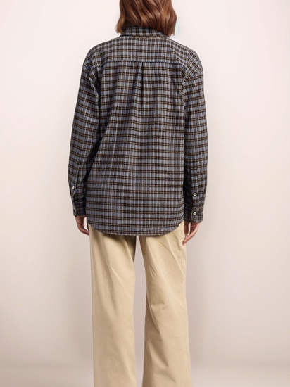 Person wearing a plaid shirt and beige pants on a plain background