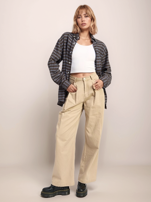 Person wearing a plaid shirt, white top, beige pants, and black shoes on a plain background