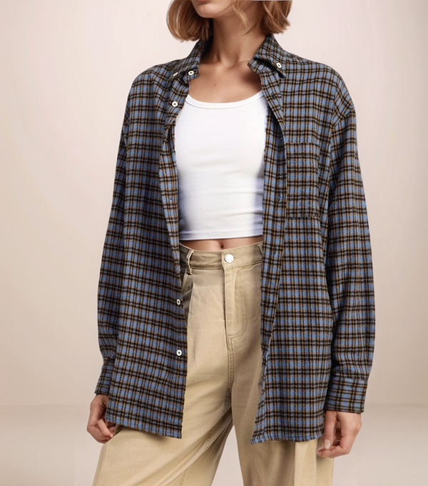 Person wearing a plaid shirt over a white crop top and beige pants on a beige background