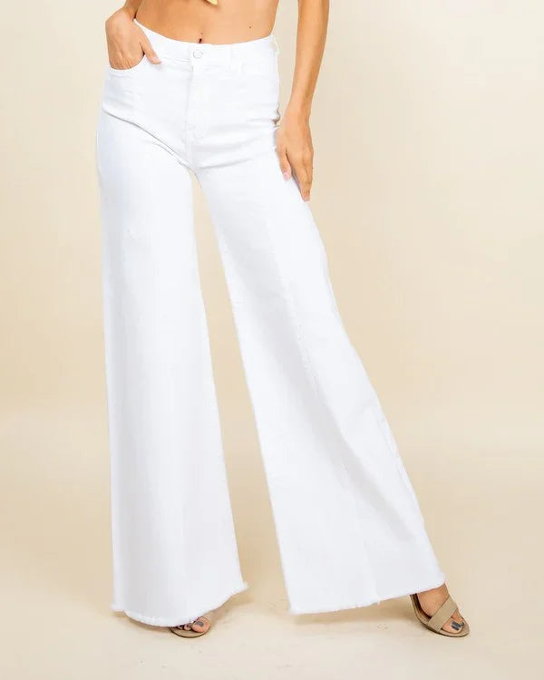 White wide-leg pants worn by a person on a beige background