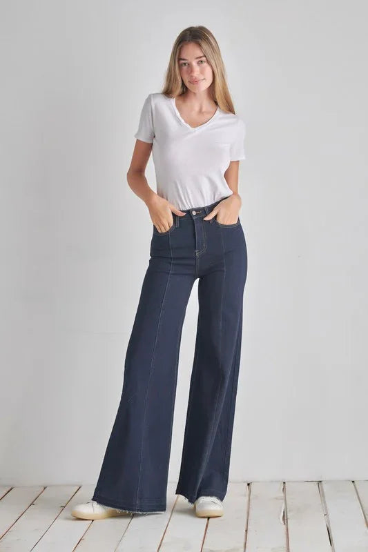 Woman wearing a white t-shirt and navblue jeans on a white background 