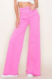 Person wearing bright pink wide-leg jeans on a plain background
