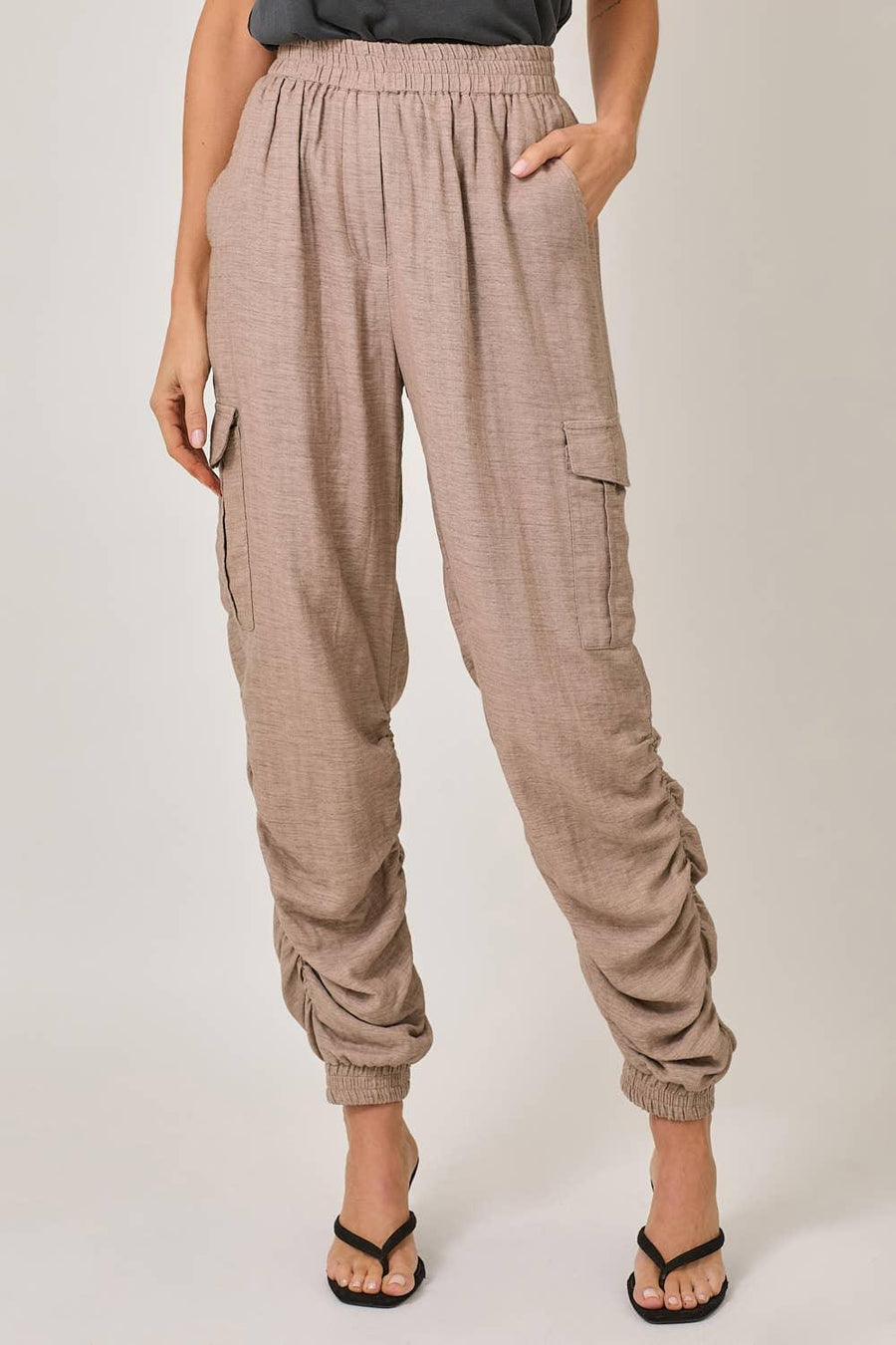 Beige cargo jogger pants worn by a person on a plain background