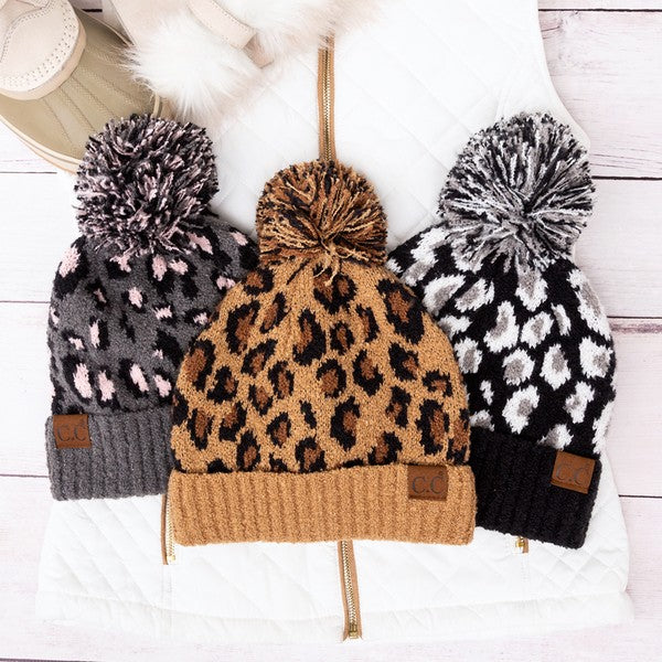 Three knitted hats with pom-poms on a white background