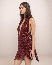Woman wearing a red sequin dress against a plain background