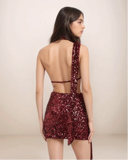 Woman wearing a red sequin dress with a beige background