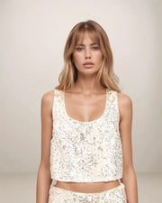 woman wearing an ivory sequin tank top and matching bottom