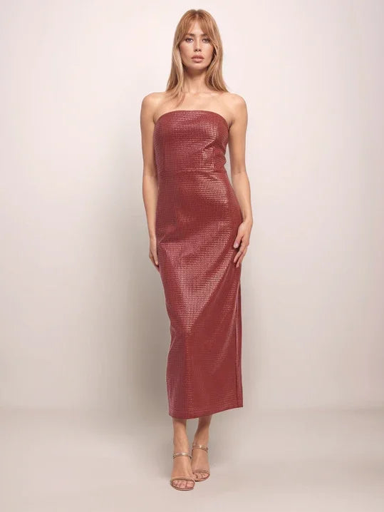 Woman wearing a strapless burgundy dress against a plain background