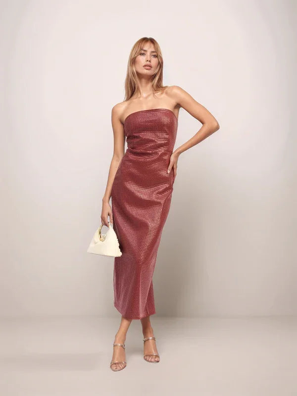 Woman wearing a strapless red dress against a plain background