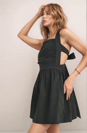 Black Maeve mini dress side view showing ruched bodice, side cutout, and flattering A-line silhouette