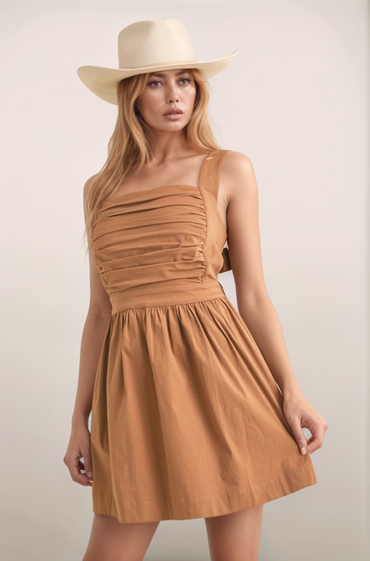 Maeve mini dress in the color chocolate front view with smocked bodice, square neckline, wide straps, and A-line skirt styled with a western hat