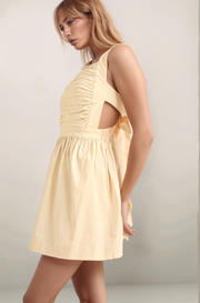 Maeve mini dress, in the color oat, side view showing ruched bodice, side cutout, and flattering A-line silhouette